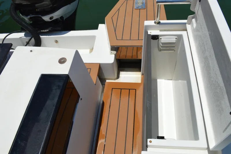 Slide: The Image of 2015 Axopar T-Top boat deck with storage compartment and teak flooring. - 32