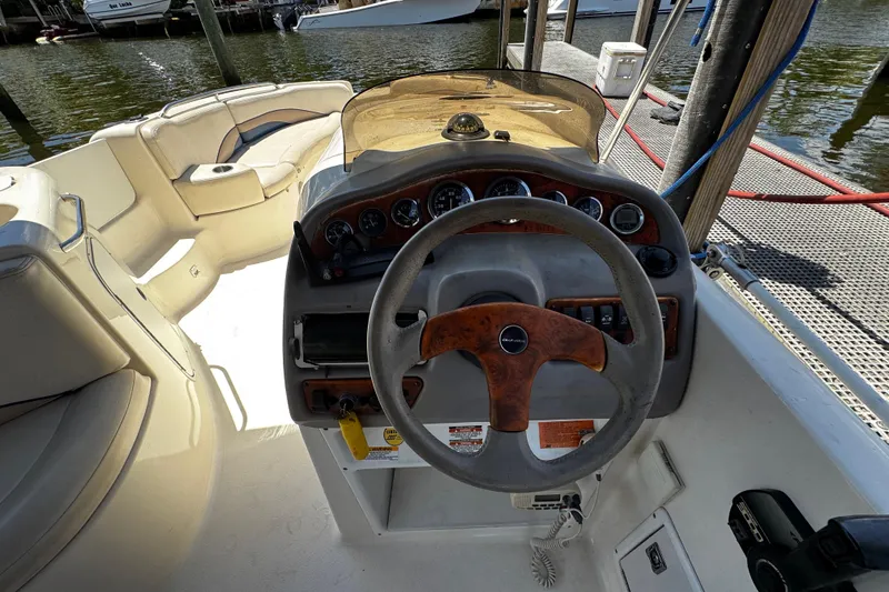 Slide: The Image of 2000 Chaparral Sunesta 232 boat helm with steering wheel and dashboard controls. - 12