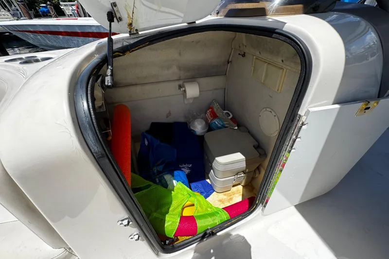 Slide: The Image of 2000 Chaparral Sunesta 232 boat storage compartment with various items inside. - 19