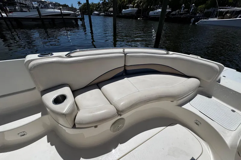 Slide: The Image of 2000 Chaparral Sunesta 232 boat interior with white seating and cup holder by the water. - 28