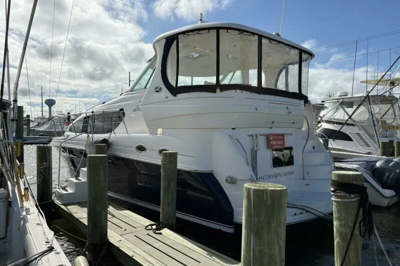 Slide: The Image of 2006 Sea Ray 40 Motor Yacht docked, for sale sign visible, under partly cloudy sky. - 1