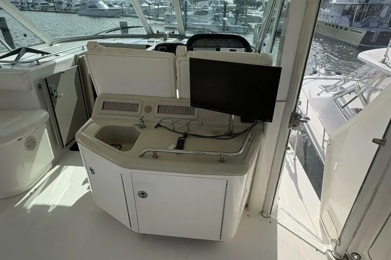 Slide: The Image of 2006 Sea Ray 40 Motor Yacht interior with helm, sink, and monitor, docked at marina. - 18