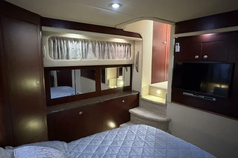 Slide: The Image of Interior of 2006 Sea Ray 40 Motor Yacht with bed, TV, and wooden cabinetry. - 35