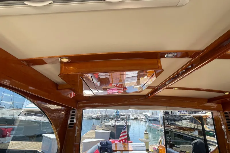 Slide: The Image of Interior view of 2017 Hinckley Talaria 43 Motoryacht with polished wood and marina backdrop. - 11