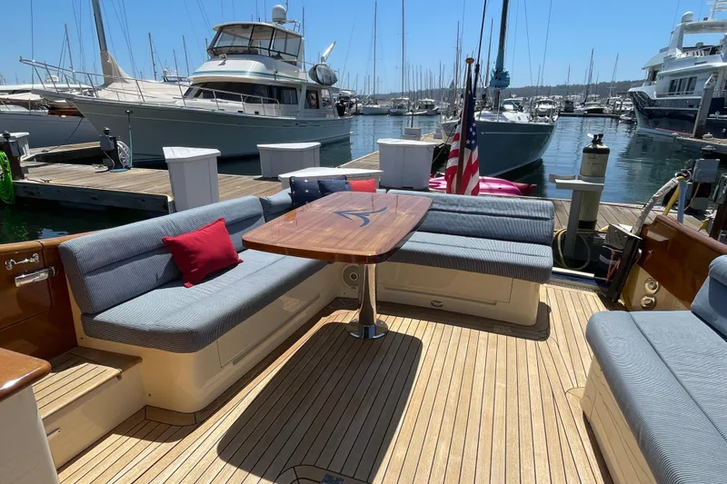 Slide: The Image of Hinckley Talaria 43 Motoryacht 2017, elegant deck seating, docked in a marina. - 2