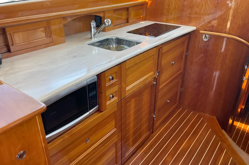 Slide: The Image of Luxurious 2017 Hinckley Talaria 43 Motoryacht kitchen with wood cabinetry and modern appliances. - 22