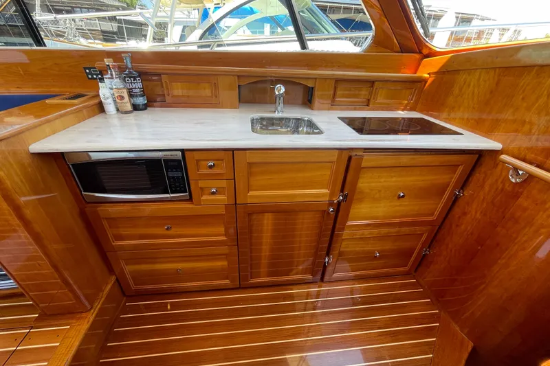 Slide: The Image of Luxurious galley in 2017 Hinckley Talaria 43 Motoryacht with wood cabinetry and modern appliances. - 23