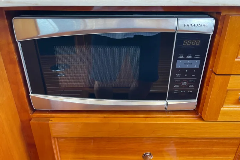 Slide: The Image of Frigidaire microwave in 2017 Hinckley Talaria 43 Motoryacht kitchen, set in wooden cabinetry. - 24