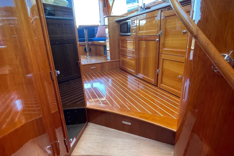Slide: The Image of Luxurious wooden interior of 2017 Hinckley Talaria 43 Motoryacht, showcasing polished cabinetry and flooring. - 26