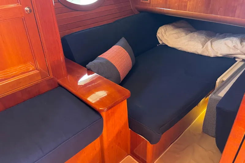 Slide: The Image of Cozy interior of 2017 Hinckley Talaria 43 Motoryacht with wooden finish and navy cushions. - 30