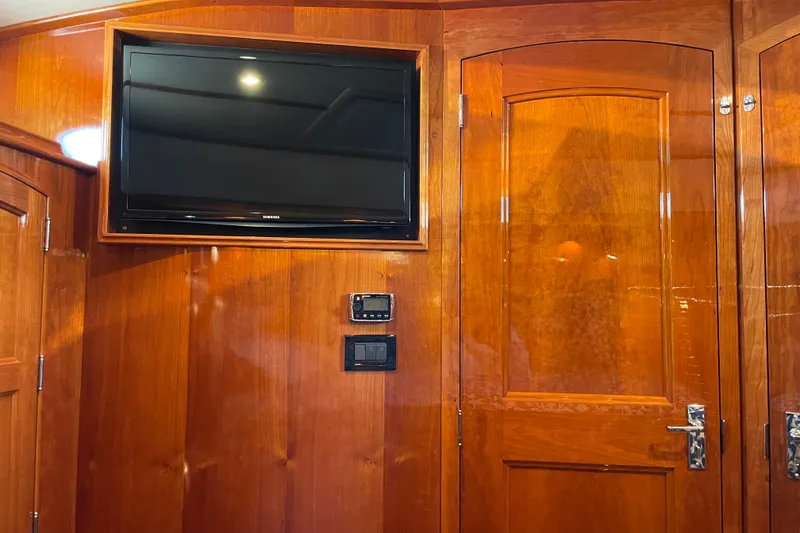 Slide: The Image of Hinckley Talaria 43 Motoryacht 2017 interior with wood paneling and mounted TV. - 33