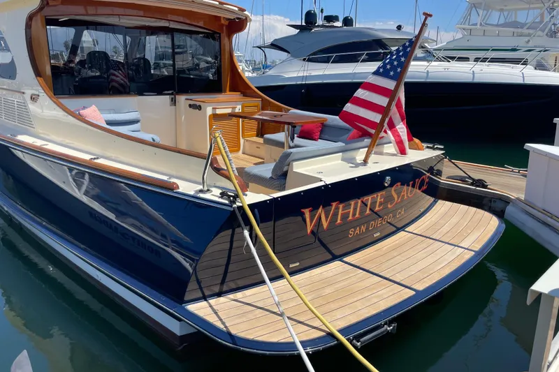 Slide: The Image of 2017 Hinckley Talaria 43 Motoryacht docked, featuring elegant design and American flag. - 38