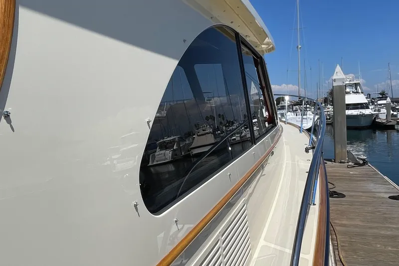 Slide: The Image of 2017 Hinckley Talaria 43 Motoryacht docked at marina, showcasing sleek design and reflective windows. - 41