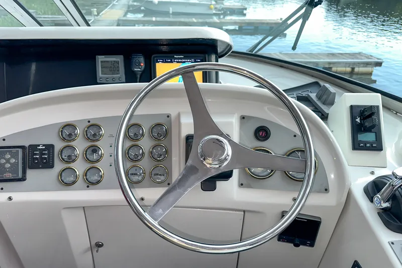 Slide: The Image of Steering wheel and dashboard of 2012 Bluewater 5200 boat, featuring multiple gauges and controls. - 12