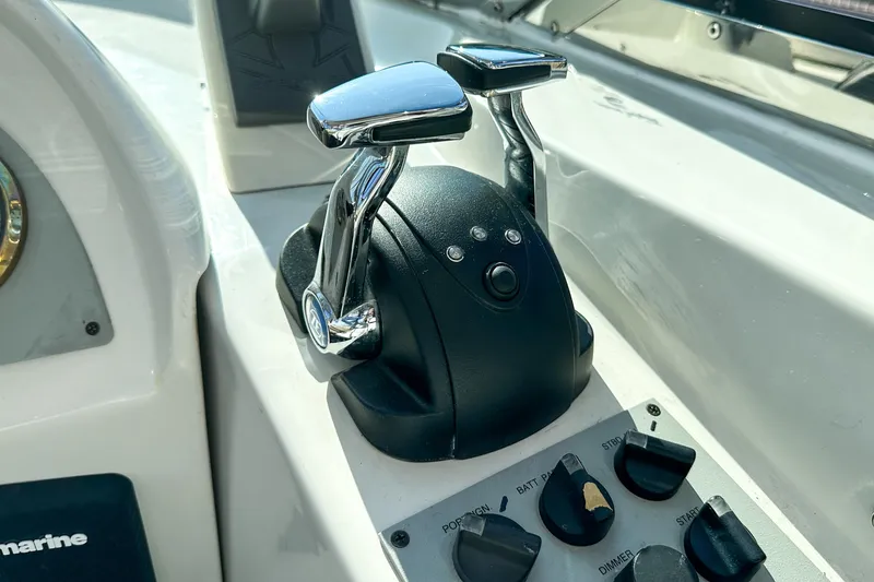 Slide: The Image of Control panel of a 2012 Bluewater 5200 boat with throttle levers and switches. - 13