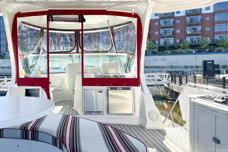 Slide: The Image of Luxurious 2012 Bluewater 5200 yacht interior with red accents, docked near modern buildings. - 17