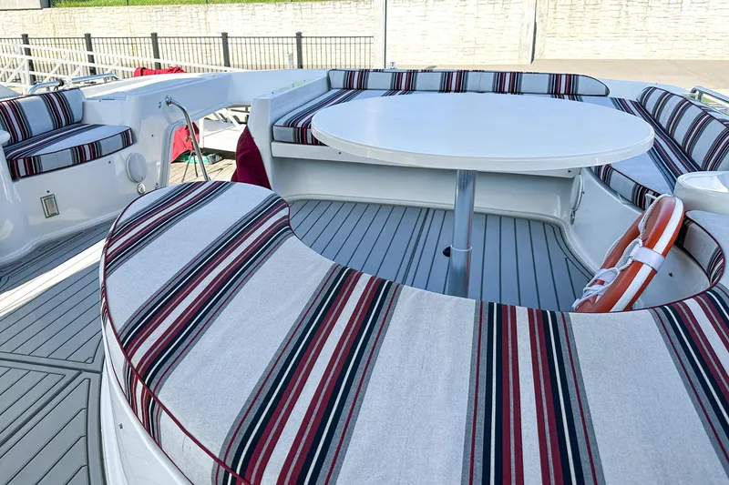 Slide: The Image of Luxurious 2012 Bluewater 5200 yacht with striped seating and round table on deck. - 21