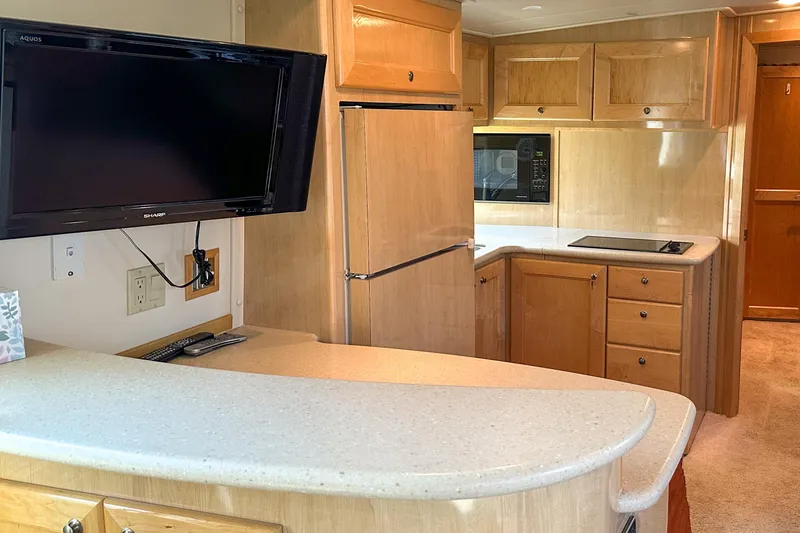 Slide: The Image of Interior of 2012 Bluewater 5200 Custom Series Yacht with kitchen and TV setup. - 33