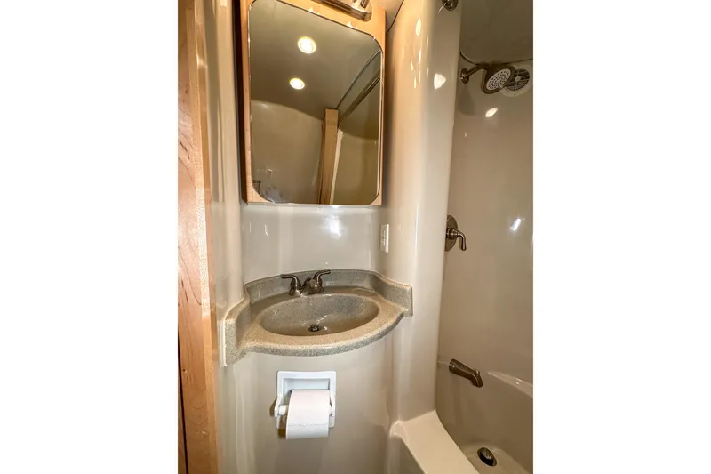 Slide: The Image of Compact bathroom in 2012 Bluewater 5200 Custom Series Yacht with sink, mirror, and shower. - 38