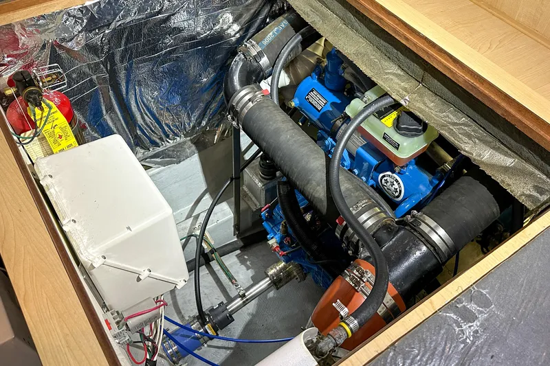 Slide: The Image of Engine compartment of 2012 Bluewater 5200 Custom Series Yacht with visible components and fire extinguisher. - 49