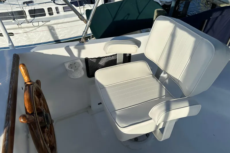 Slide: The Image of Captain's chair and wooden helm on a 1973 CHB 34 boat deck. - 11