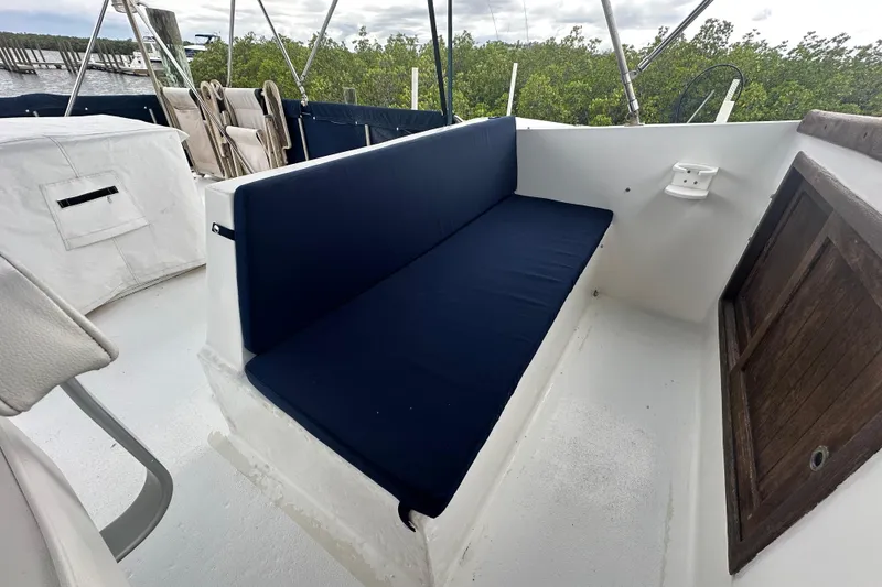 Slide: The Image of Blue cushioned seating on 1973 CHB 34 boat deck, surrounded by greenery. - 13