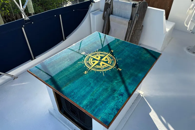 Slide: The Image of 1973 CHB 34 boat deck with a compass rose design table. - 14