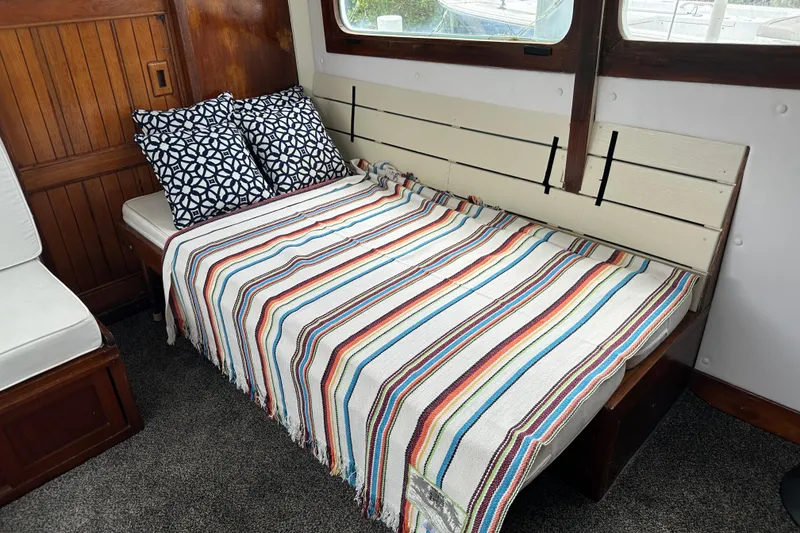 Slide: The Image of Cozy cabin interior of 1973 CHB 34 with striped blanket and patterned pillows. - 20