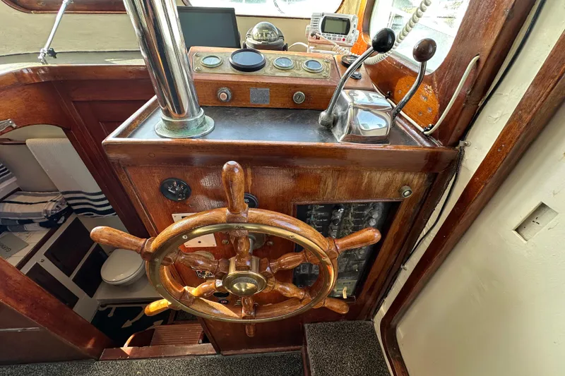 Slide: The Image of 1973 CHB 34 boat helm with wooden wheel and navigation controls. - 23