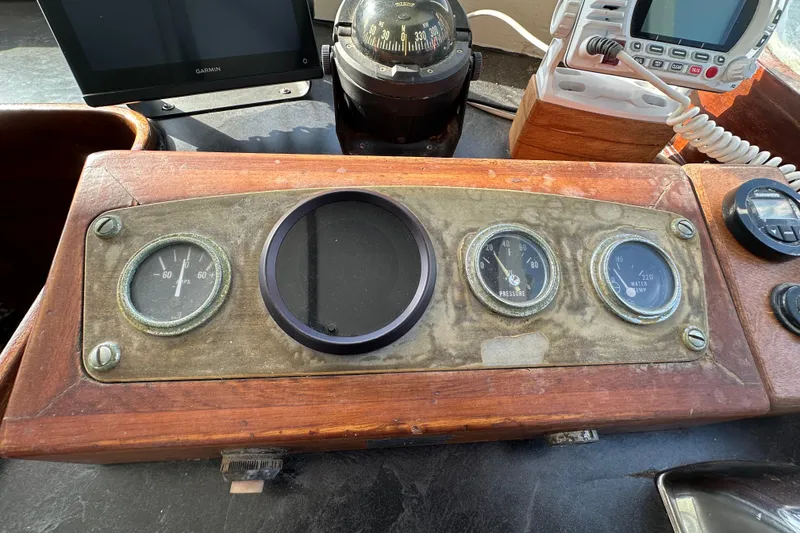 Slide: The Image of 1973 CHB 34 boat dashboard with vintage gauges and navigation equipment. - 24