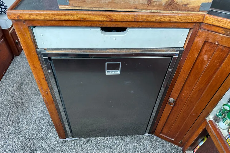 Slide: The Image of Vintage 1973 CHB 34 boat interior with wooden cabinetry and built-in refrigerator. - 28