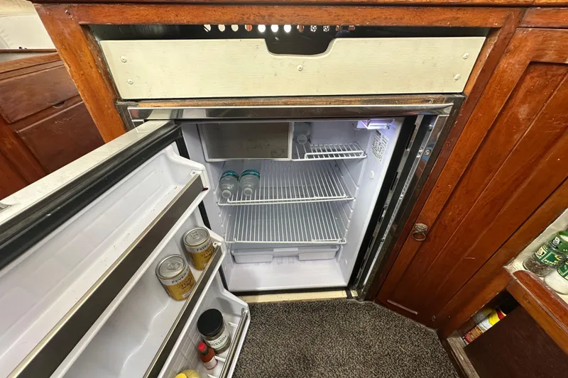 Slide: The Image of Open refrigerator in a 1973 CHB 34 boat, stocked with drinks and canned goods. - 29