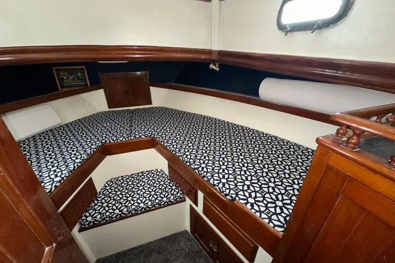 Slide: The Image of 1973 CHB 34 boat cabin with patterned bedding and wooden interior. - 34
