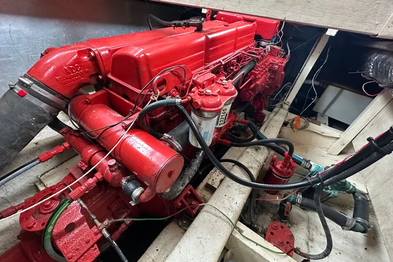 Slide: The Image of Red engine inside a 1973 CHB 34 boat, showcasing detailed mechanical components. - 44
