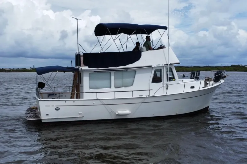Slide: The Image of 1973 CHB 34 boat cruising on a calm waterway under a cloudy sky. - 5