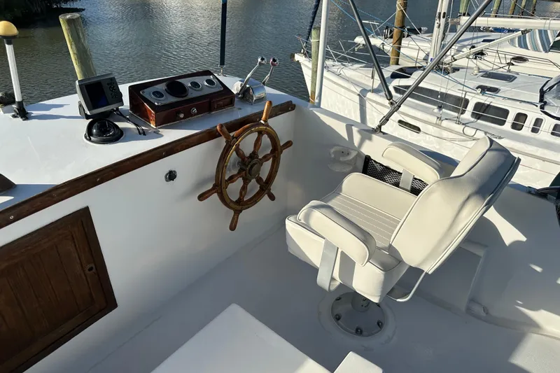 Slide: The Image of 1973 CHB 34 boat helm with wooden wheel and white captain's chair. - 10