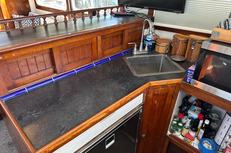 Slide: The Image of 1973 CHB 34 boat kitchen with wooden cabinetry, sink, and countertop appliances. - 27