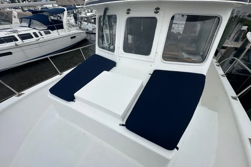 Slide: The Image of 1973 CHB 34 boat deck with blue cushions and white cabin windows. - 8