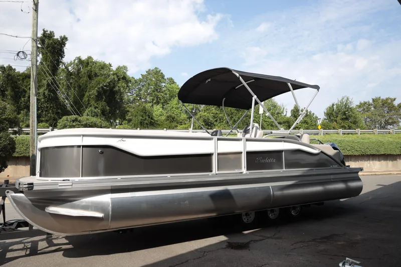 Slide: The Image of 2026 Barletta ARIA 22UC pontoon boat with canopy, parked outdoors. - 3