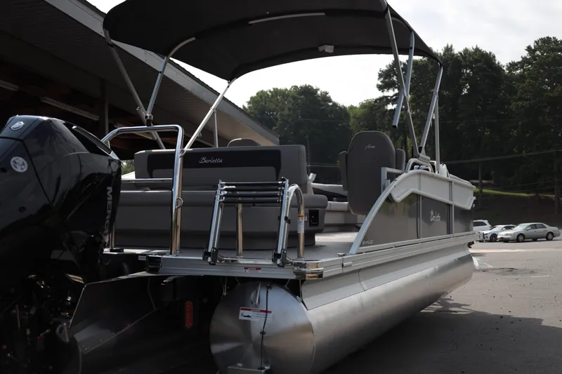 Slide: The Image of 2026 Barletta ARIA 22UC pontoon boat with canopy and seating, parked outdoors. - 5