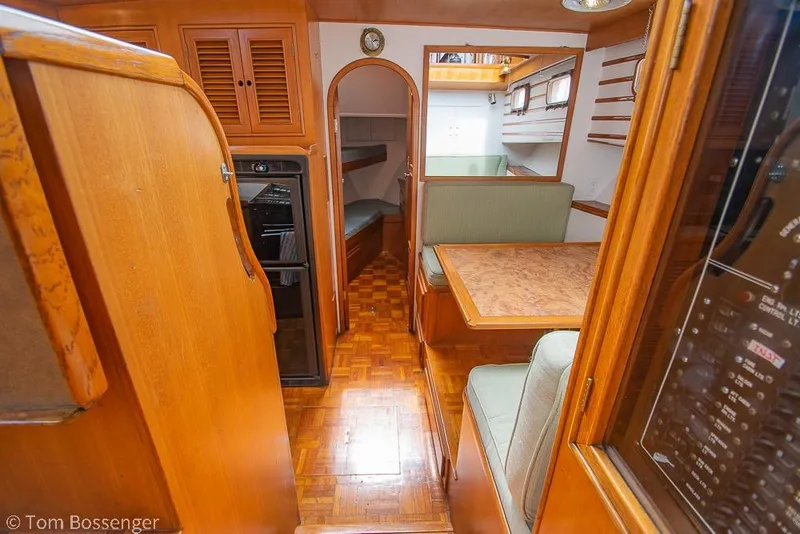Slide: The Image of Interior of 1986 Ponderosa 47 yacht with wood finish and cozy seating area. - 12