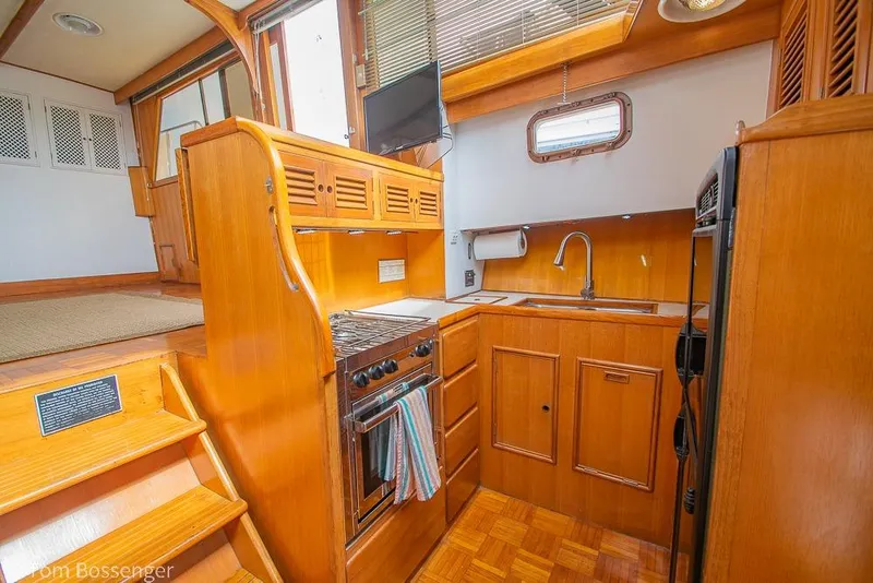Slide: The Image of 1986 Ponderosa 47 yacht kitchen with wooden cabinetry, stove, and sink. - 13