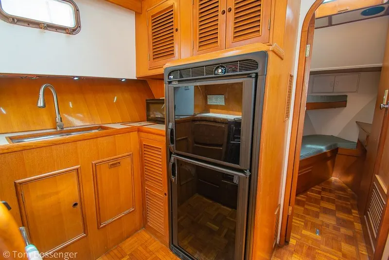 Slide: The Image of 1986 Ponderosa 47 yacht interior with wooden kitchen and compact sleeping area. - 16