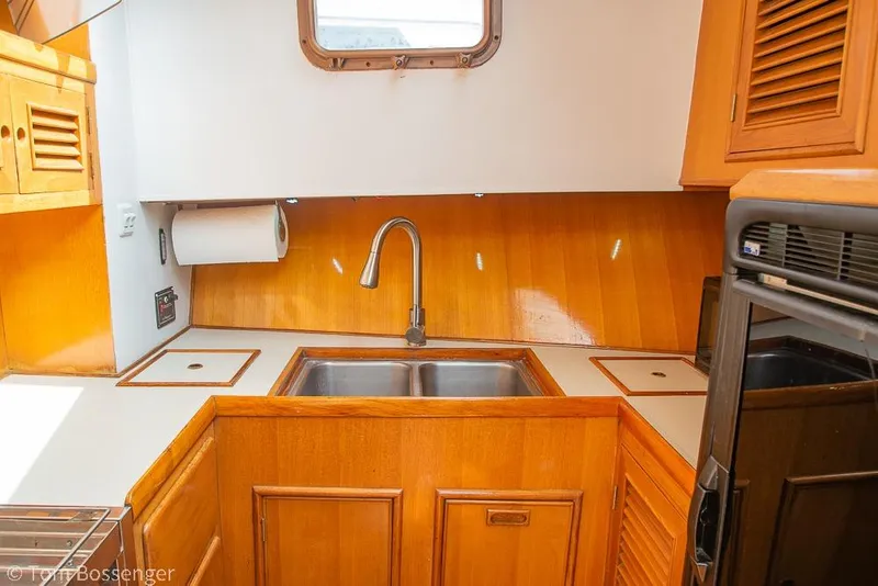 Slide: The Image of 1986 Ponderosa 47 yacht kitchen with wooden cabinets and stainless steel sink. - 17