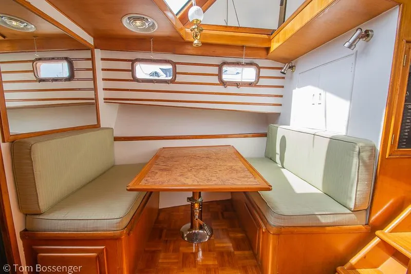 Slide: The Image of Cozy dining area in 1986 Ponderosa 47 yacht with wood accents and cushioned seating. - 18