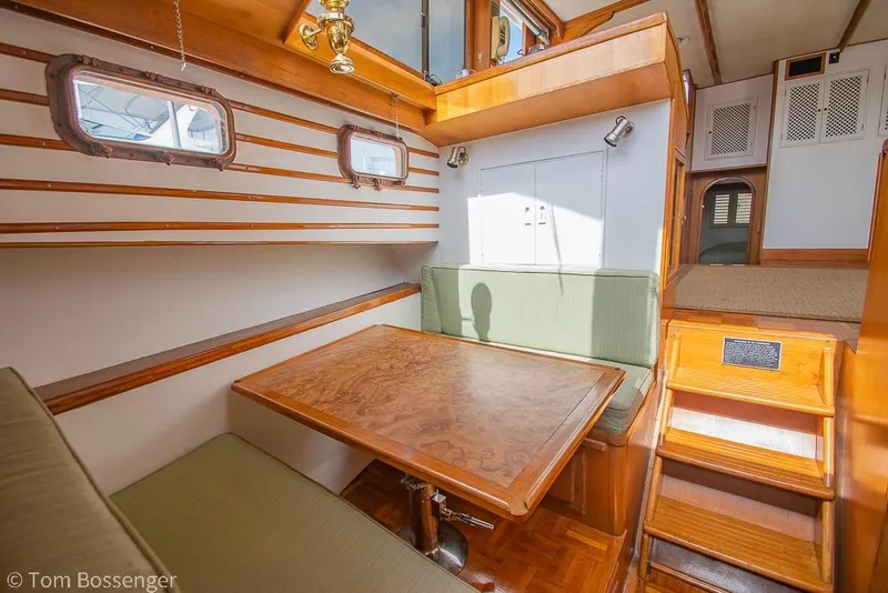 Slide: The Image of Cozy interior of 1986 Ponderosa 47 yacht with wooden dining area and green seating. - 19