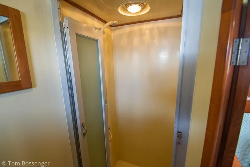 Slide: The Image of Compact shower area in a 1986 Ponderosa 47 boat, featuring a frosted glass door. - 27