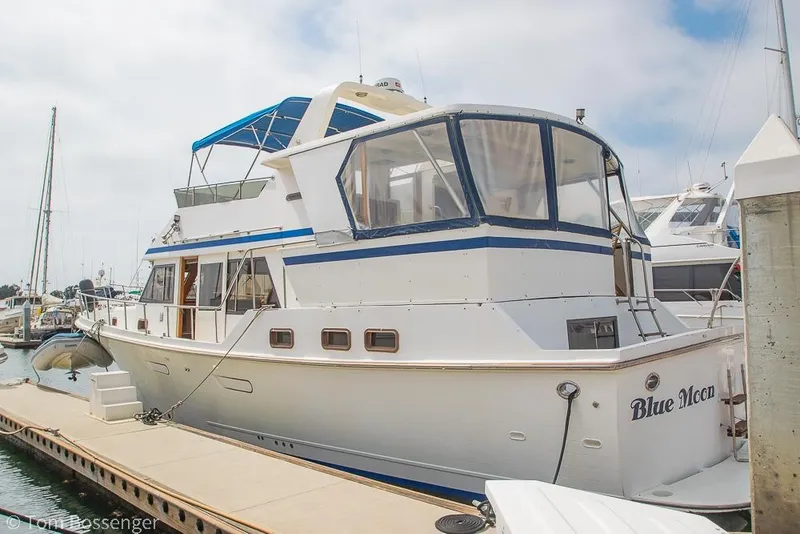 Slide: The Image of 1986 Ponderosa 47 yacht named "Blue Moon" docked at a marina. - 3