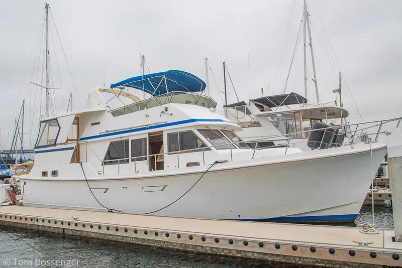 Slide: The Image of 1986 Ponderosa 47 yacht docked at marina with blue canopy and white hull. - 4