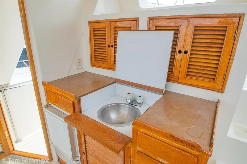 Slide: The Image of 1986 Ponderosa 47 yacht interior with wooden cabinets and compact sink area. - 41
